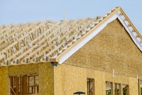 Photo of roof trusses newly installed on a home that is being built. 